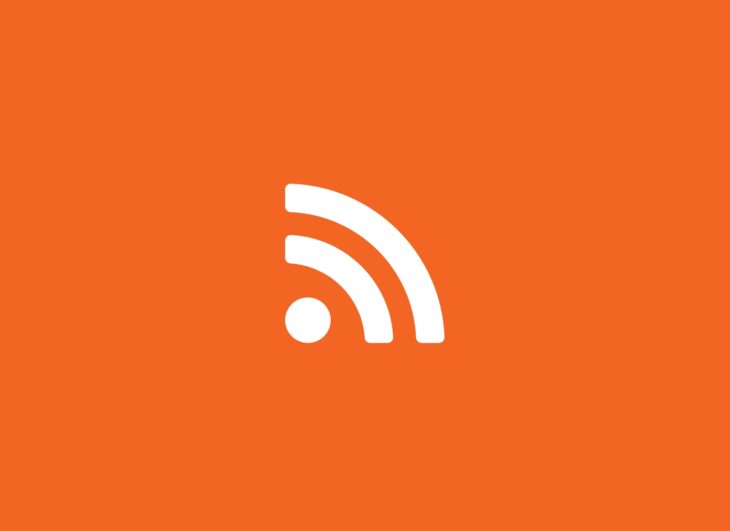 Weisses RSS-Logo, dargestellt auf orangem Hintergrund.